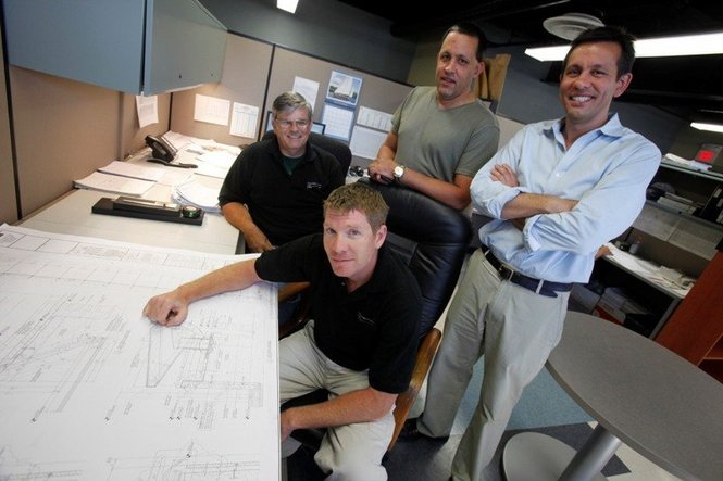 (L-R standing) Brothers, Joe and Jim Moretti, of Service Metal Fabricators of Rockaway, along with project engineers (L-R) Doug Reeve and Brian Wyckoff with drawings of the 9/11 memorial the company will be making for Ground Zero. The company, run by two generations of the Moretti Family, is creating nameplates with all 2,982 names of the victims of the 9/11 attack on the World Trade Center. Robert Sciarrino/The Star-Ledger